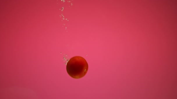 Красный перец и помидоры падают в воду с пузырьками в замедленной съемке — стоковое видео