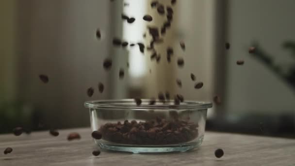 Koffiebonen vallen in een glazen plaat in extreme slow motion 150fps — Stockvideo