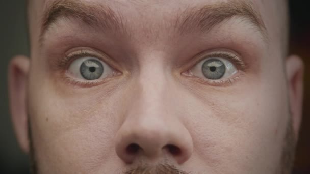 Acercamiento de los ojos de un hombre caucásico adulto sorprendido con sus cejas tirando hacia arriba — Vídeos de Stock