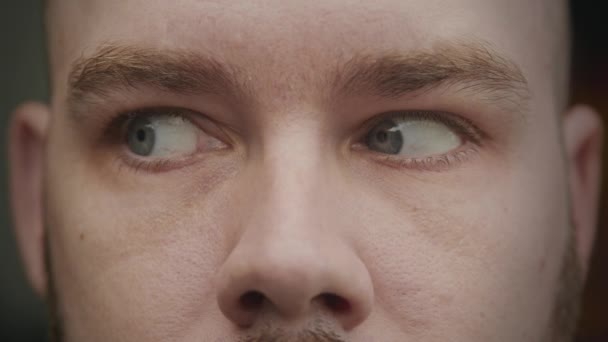 Detailní záběr na bělocha dospělý muž modré oči dívá ze strany na stranu — Stock video