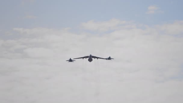 Zbliżenie wojskowego samolotu towarowego, któremu towarzyszyły dwa myśliwce lecące w zwolnionym tempie 120 fps — Wideo stockowe