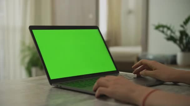 Padella lenta sulle mani caucasiche delle donne che posano su un computer portatile con uno schermo verde all'interno — Video Stock