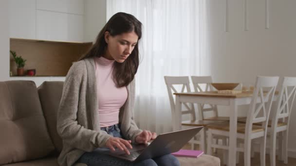 Genç yirmili yaşlarda beyaz bir bayan öğrenci laptopunda bir sınavı geçiyor ve başarısını açıkça kutluyor. — Stok video