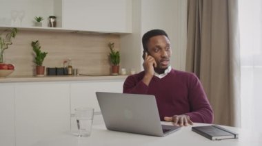 Genç 20 'li yaşlarda Afro-Amerikan siyah satış müdürü telefonla konuşuyor ve satışı mutlu ve keyifli yapıyor.