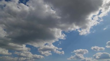 Parlak mavi bir gökyüzünde yuvarlanan kara bulutların dramatik bir görüntüsü değişen havayı ve yaklaşan fırtına koşullarını simgeliyor..