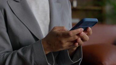 Akıllı bir telefonla el ele tutuşup daktilo ederken cep telefonu mesajları, dijital iletişim ve günlük telefon kullanımını gösteriyor..