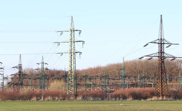 Transformatör istasyonunun önündeki yüksek voltajlı elektrik direkleri. Elektrik hatları. Elektrik dağıtım ağı.