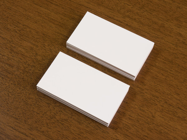 Piles of business cards on a wooden desk