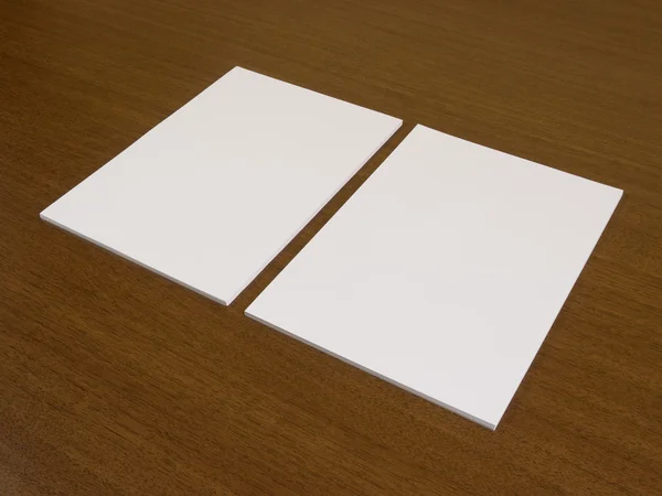 Two blank white papers on a wooden background. Stock Picture