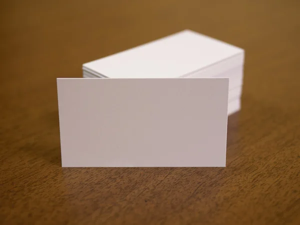 Cartões de visita em branco desfocados sobre um fundo de madeira — Fotografia de Stock