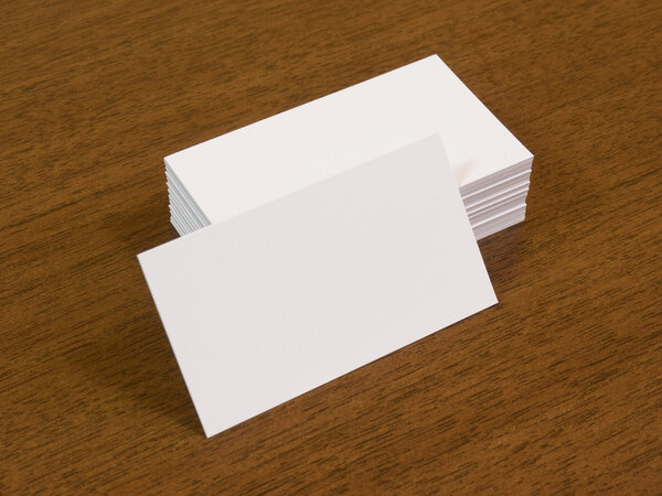 Blank business cards on brown wooden table.