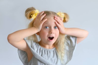 Kız şaşkınlıkla kafasını tutuyor.