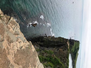 Kaya, uçurum, deniz, gökyüzü.