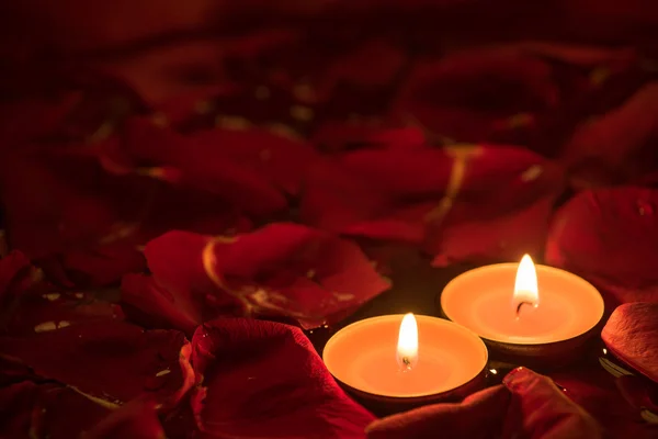 Two candles and rose petals — Stock Photo, Image