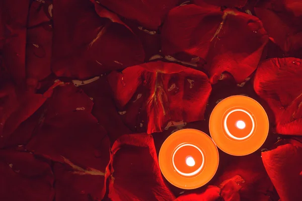 Zwei Kerzen und Rosenblätter Hintergrund — Stockfoto