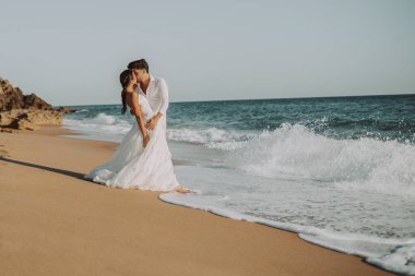 Düğün kumsalı genç çift gün batımı kum beyaz mutlu deniz dalgaları