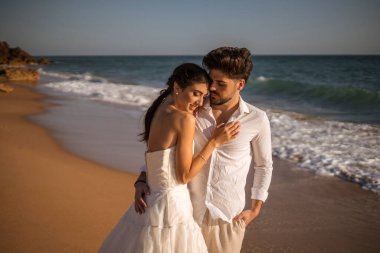 Düğün kumsalı genç çift gün batımı kum beyaz mutlu deniz dalgaları