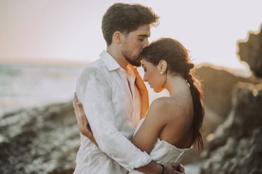 Düğün kumsalı genç çift gün batımı kum beyaz mutlu deniz dalgaları