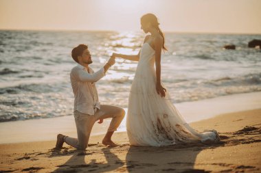 Düğün kumsalı genç çift gün batımı kum beyaz mutlu deniz dalgaları