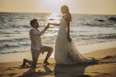 Düğün kumsalı genç çift gün batımı kum beyaz mutlu deniz dalgaları