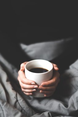 Bir fincan kahve tutan kadın.