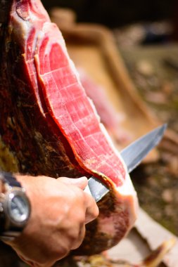 Kurutulmuş İtalyan jambonlu jambonu dilimliyorum. Tonlanmış görüntü. Seçici odak noktası