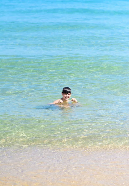 Carino e giovane ragazzo sulla spiaggia tropicale Immagine Stock