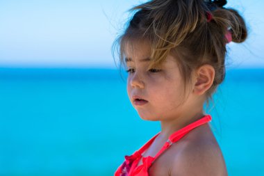Kumsal tatilinde gülümseyen sevimli küçük kız.