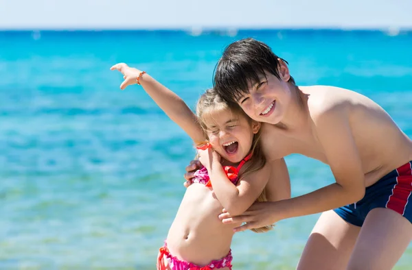 Bruder und Schwester spielen am tropischen Strand — Stockfoto