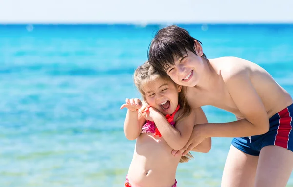 Bruder und Schwester spielen am tropischen Strand — Stockfoto