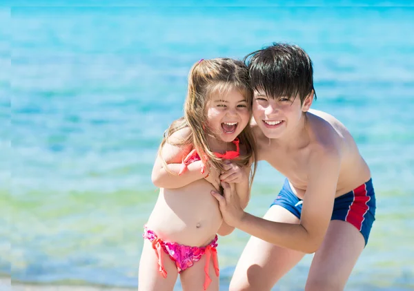 Bruder und Schwester spielen am tropischen Strand — Stockfoto