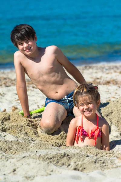 Frère et sœur jouant à la plage tropicale — Photo