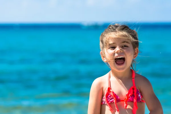 Αξιολάτρευτο χαρούμενο χαμογελαστό κοριτσάκι στις διακοπές στην παραλία — Φωτογραφία Αρχείου