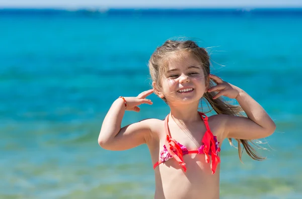 Urocza, uśmiechnięta dziewczynka na wakacjach na plaży — Zdjęcie stockowe