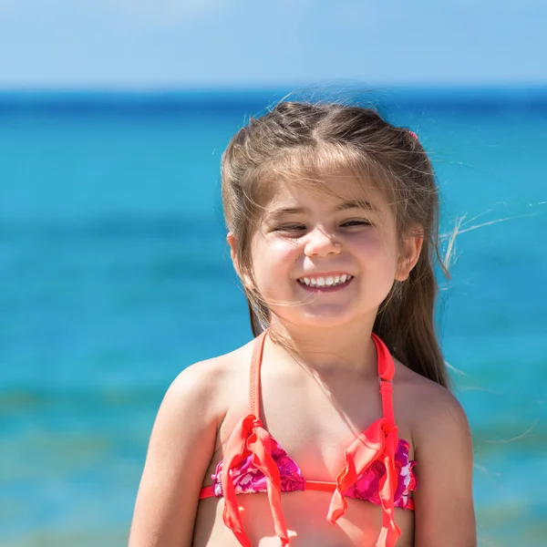 Urocza, uśmiechnięta dziewczynka na wakacjach na plaży — Zdjęcie stockowe