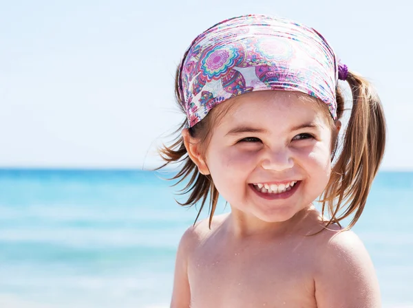 Kumsal tatilinde gülümseyen sevimli küçük kız.