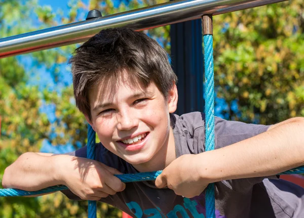 Glad ung pojke leende på park i en utomhus dag — Stockfoto