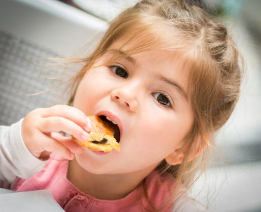 Bir kek, yakın çekim yemek güzel küçük bir kız portresi