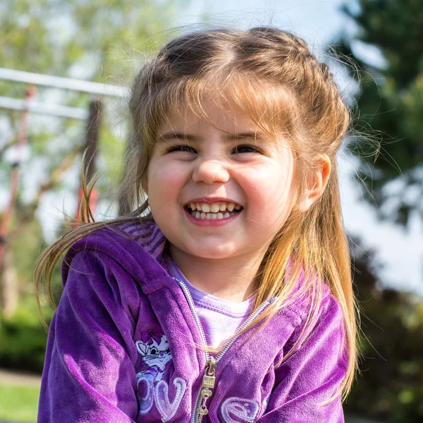 Portrait of little girl smiling and playing at the park — Stock Photo, Image