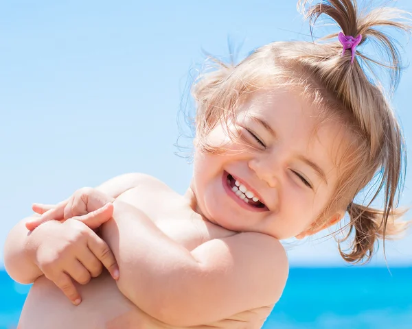 Kumsal tatilinde gülümseyen sevimli küçük kız.