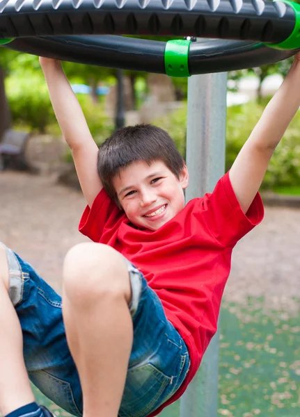 Gelukkig lachend jongen speelt in het park — Stockfoto