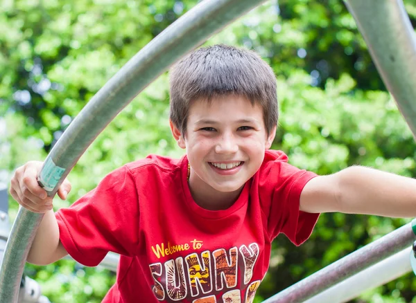 Junger glücklicher lächelnder Junge spielt im Park — Stockfoto