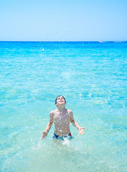 Jeune garçon heureux s'amusant sur une plage tropicale, jouant sur un sable blanc et de l'eau de mer claire — Photo