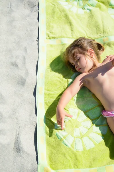 Jeune petite fille mignonne se détendre sur du sable blanc dans une serviette de plage verte — Photo