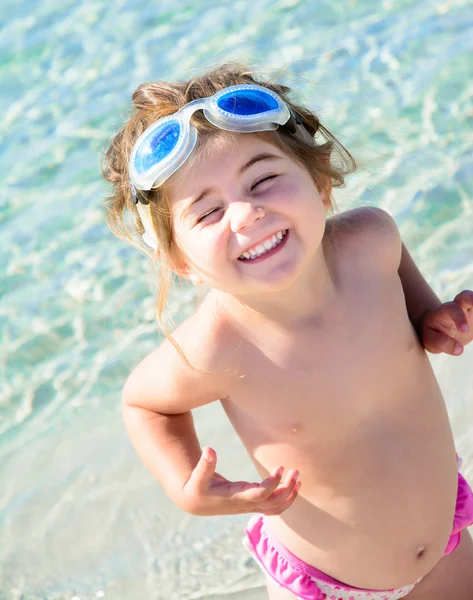 Happy tersenyum gadis kecil pada latar belakang laut yang bersih dan tropis — Stok Foto