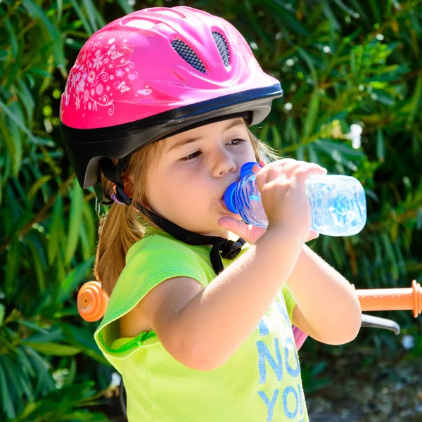 Mädchen mit Fahrrad trinkt Wasser — Stockfoto
