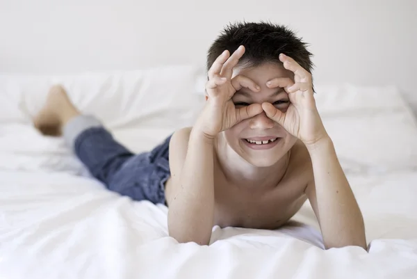 Pequeño niño sonriendo en la cama — Foto de Stock