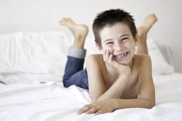 Маленький хлопчик сміється на ліжку — стокове фото