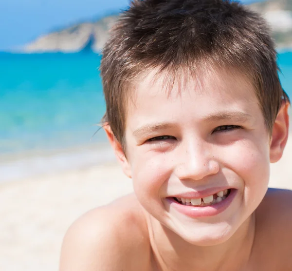 Jongen lacht op het strand — Stockfoto