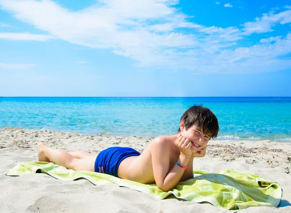 Boy lying on tropical beach — Stock Photo, Image